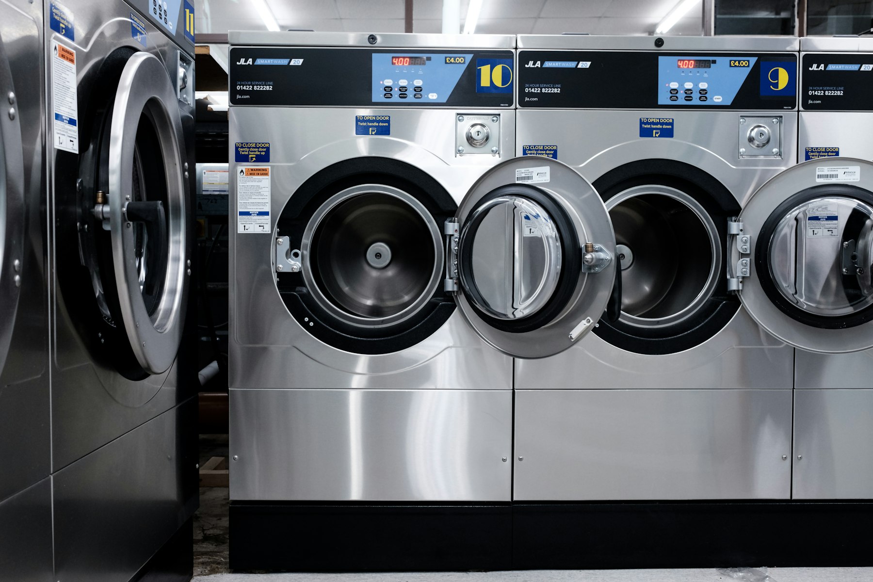 Bright renovated laundromat interior with modern chrome washers